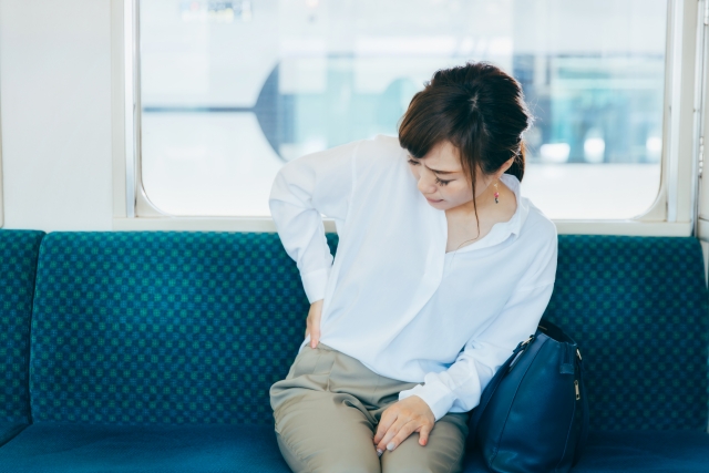 通勤中も腰痛の辛い症状に悩む女性